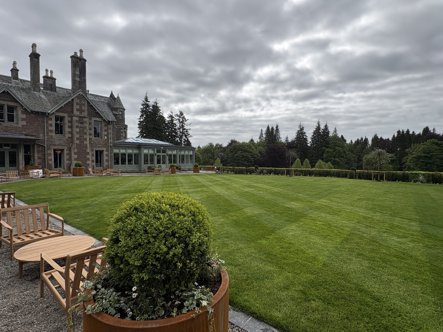 Landscaped lawn and terrace beside a stone country house